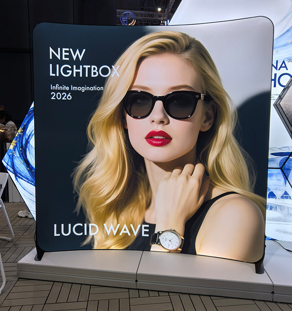 ルーシッド(Lucid)ウェーブの曲線型大型バックパネルにサングラスの女性モデルを配置した展示会での設置例|誉展示会